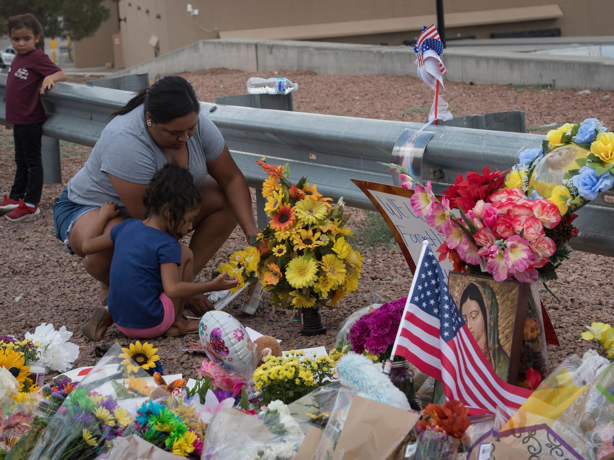 A mother and daughter lay flowers close to the site of the El Paso shooting