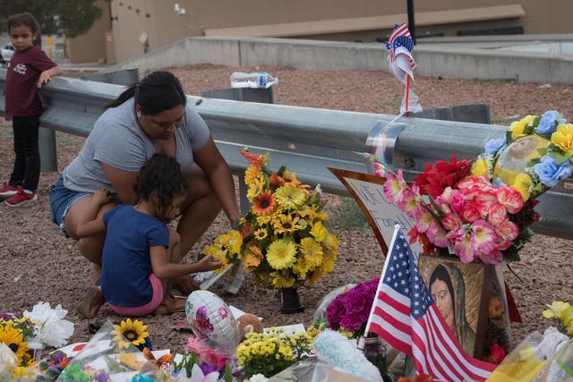 A mother and daughter lay flowers close to the site of the El Paso shooting