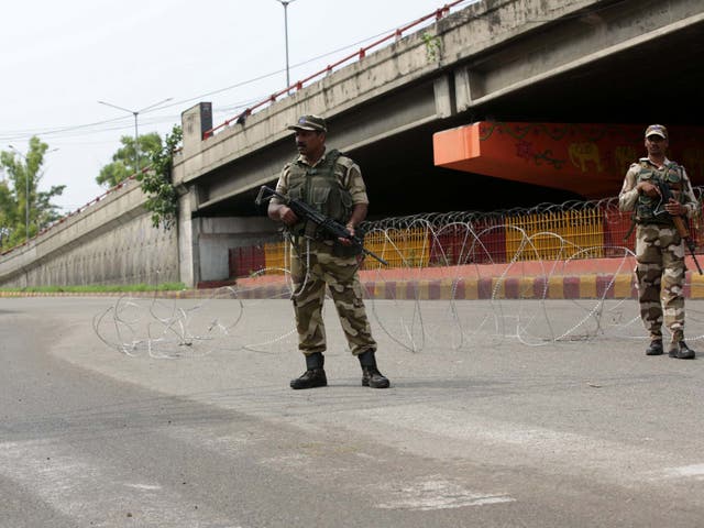 Indian soldiers stand guard during a curfew in the Kashmiri city of Jammu