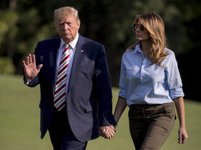 President Donald Trump waves to members of the media as he and first lady Melania Trump walk across the South Lawn of the White House in Washington on 4 August 2019, as they return from his golf club in Bedminster, New Jersey.