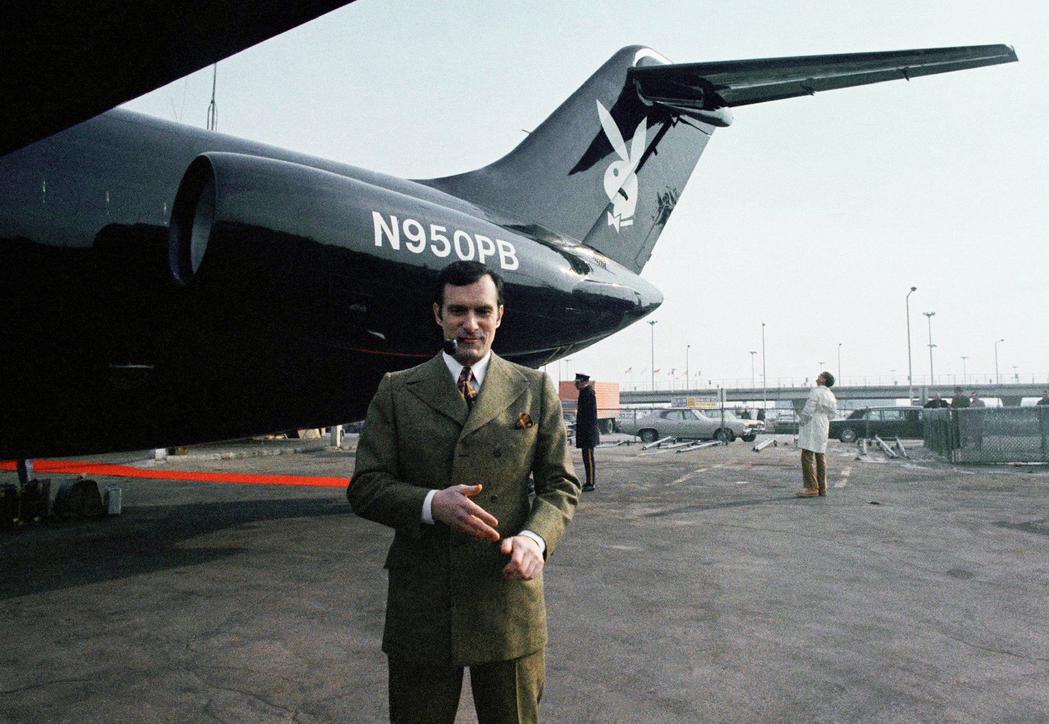 Hefner poses in front of his black jet plane in 1970