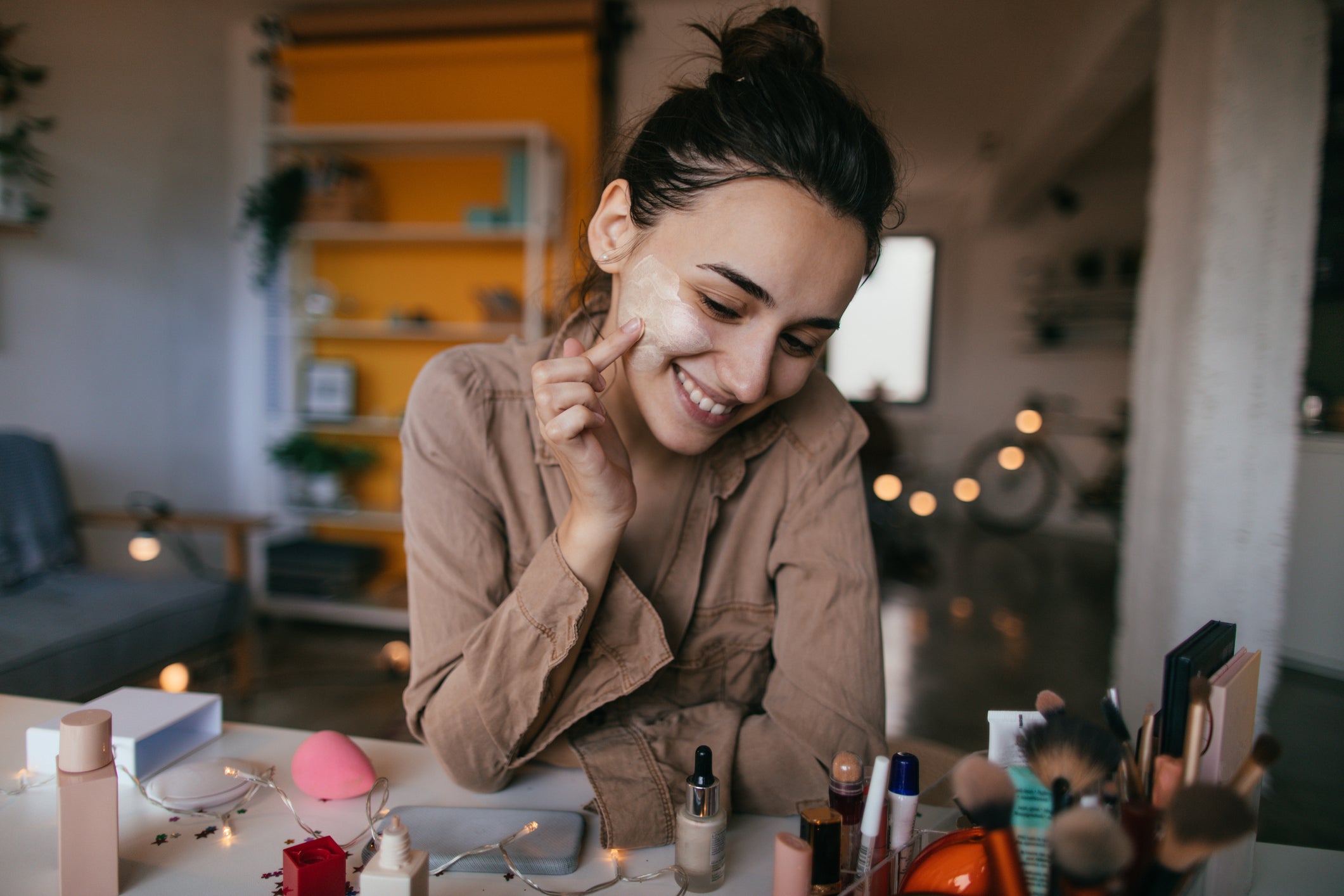 Young woman applying daily cream