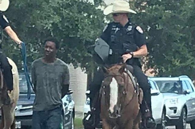 Donald Neely, 43, was forced to walk behind the mounted officers holding a rope attached to a pair of handcuffs