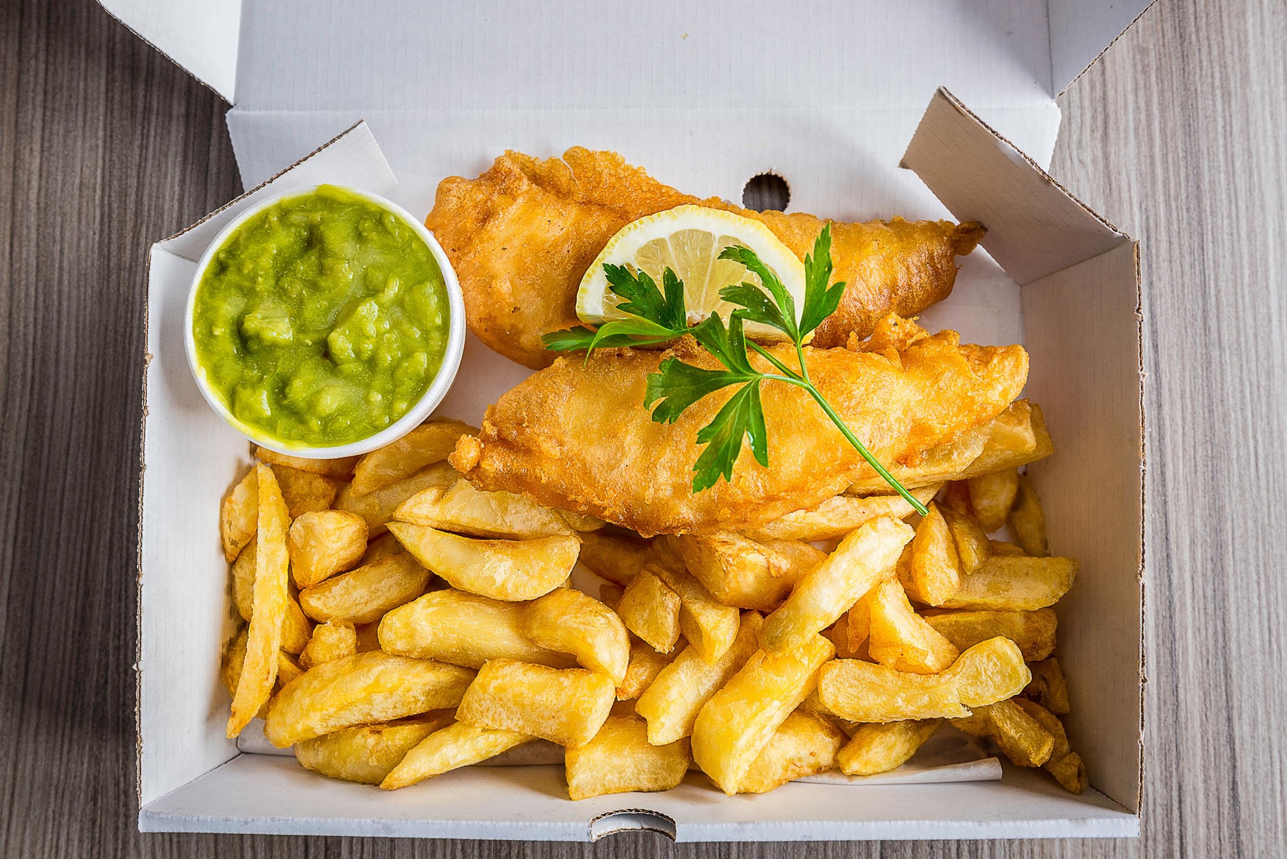 Fish and chips with peas and slice of lemon and garnish