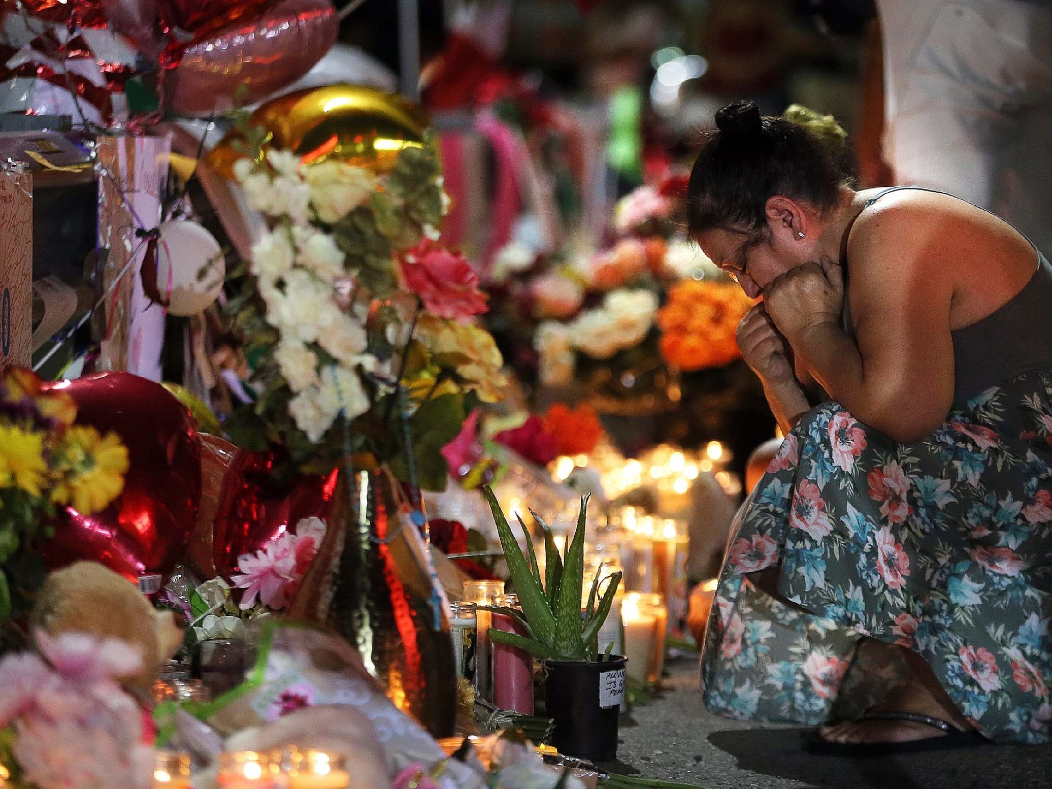 A visitor joins a vigil outside the Walmart in El Paso to pay their respects to those who lost their lives in Saturday's attack