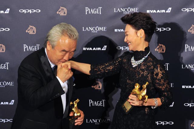 Chinese actor Tu Men, winner of the Best Leading Actor Award, kisses the hand of Hong Kong actress Kara Hui Ying-hung, also known as Kara Wai, winner of the Best Leading Actress Award, at Taiwan's 2017 Golden Horse film awards.