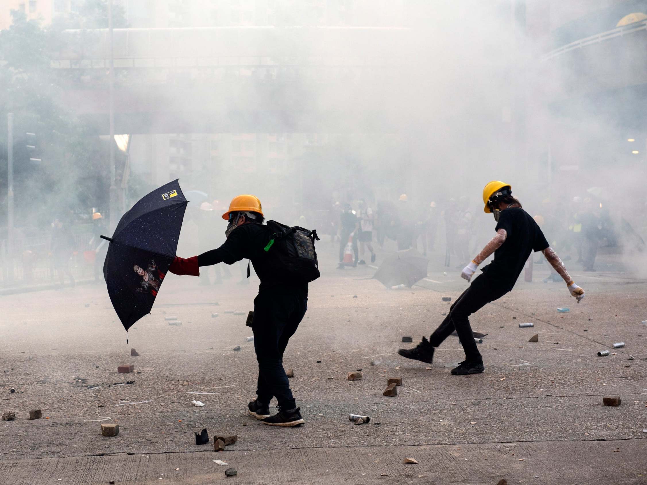 Anti-extradition protesters react after teargas is fired by police during clashes in Wong Tai Sin on 5 August
