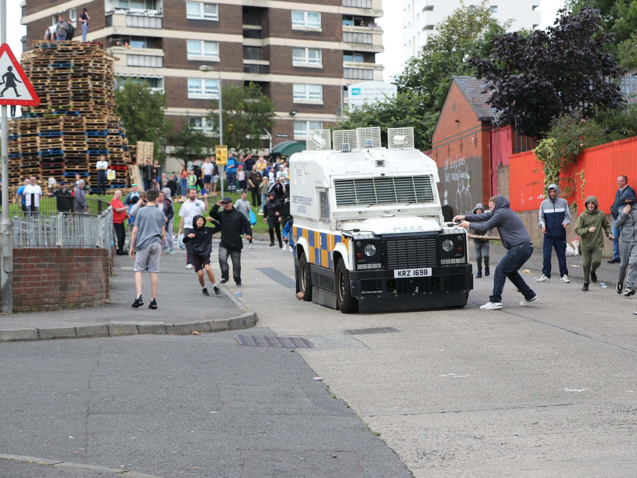 Police are attacked by youths at the site of a proposed bonfire in north Belfast, which contractors have been ordered to remove, 8 August 2019.
