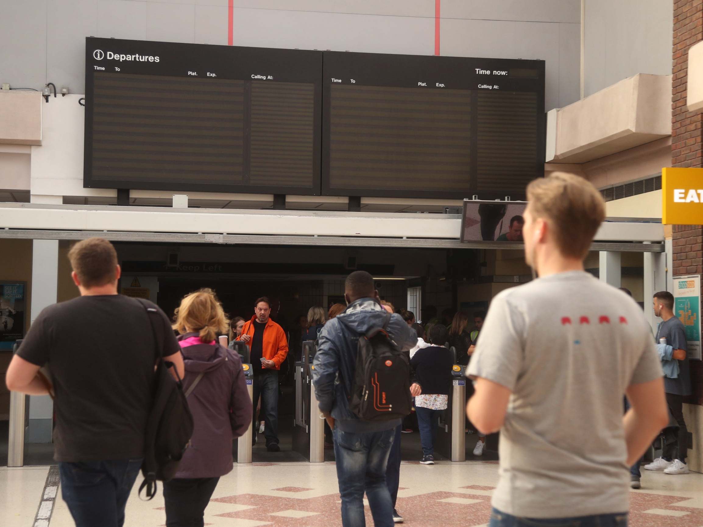People walk through Clapham Junction station in London after a power cut brought trains to a standstill and shut down traffic lights during rush hour 9 August 2019.