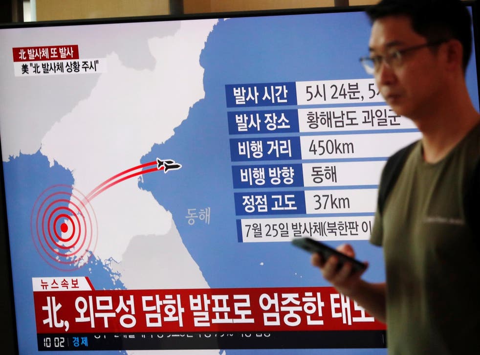 A man in Seoul walks past a TV broadcasting a news report on North Korea firing two unidentified projectiles on 6 August 2019