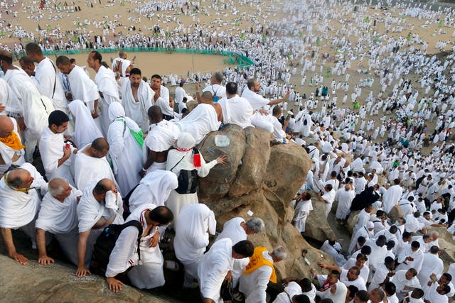 Pilgrims make their way down a rocky hill known as Mountain of Mercy, on the Plain of Arafat