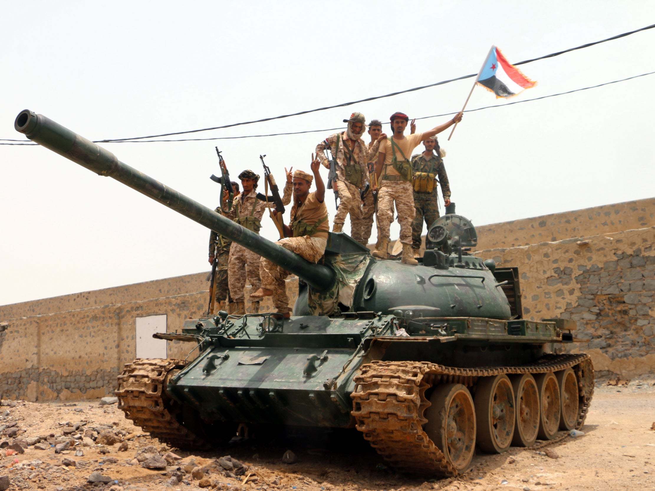 Armed members of a separatist southern group hold up a separatist flag