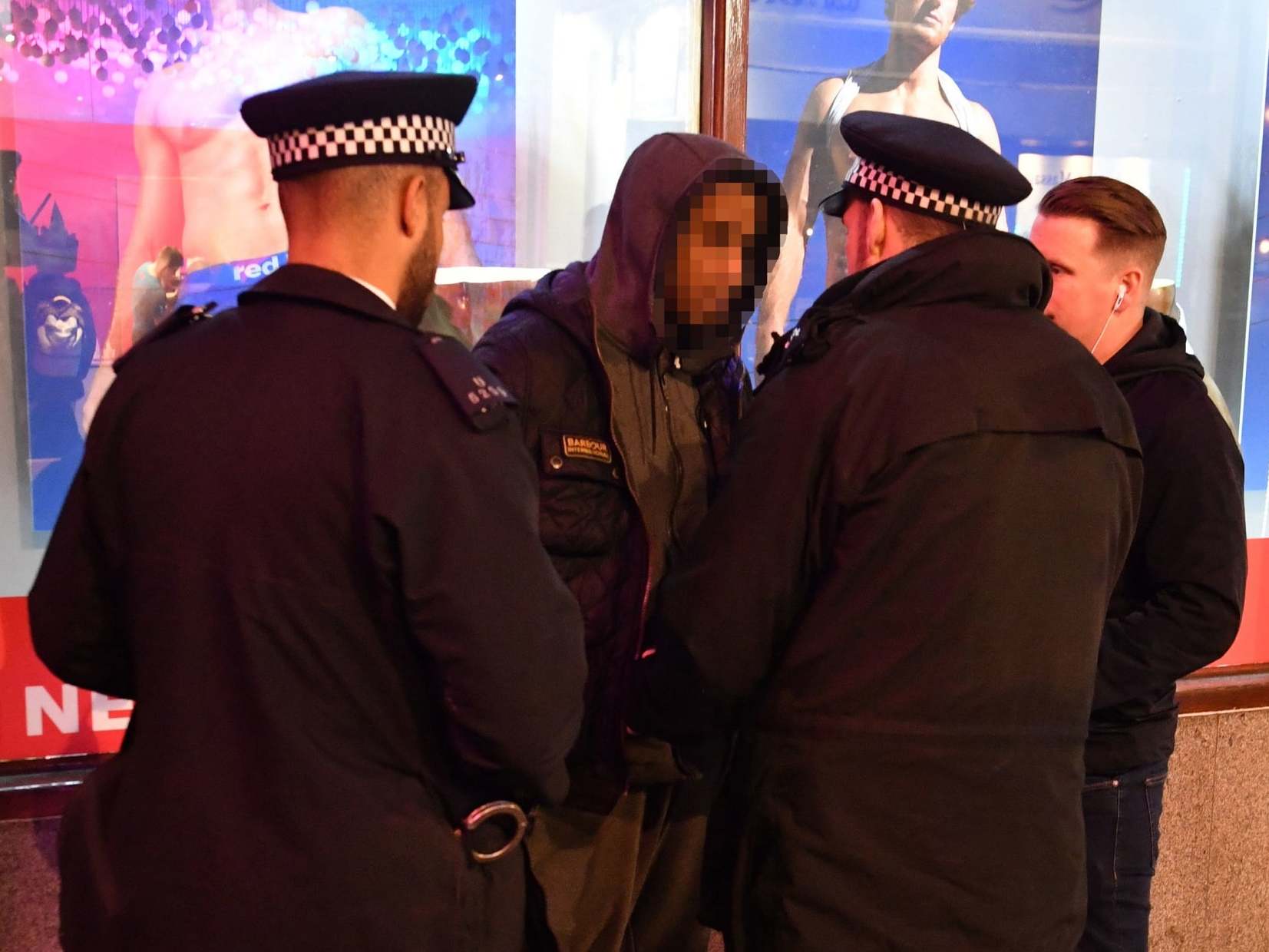 Police carry out a stop and search on a suspect in London