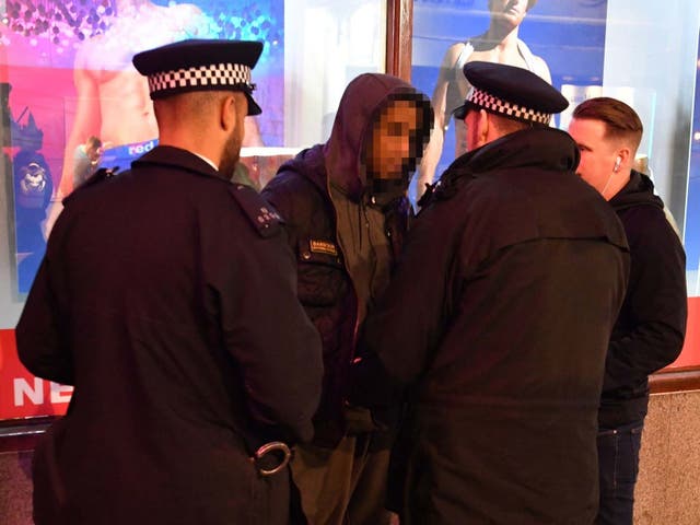 Police carry out a stop and search on a suspect in London