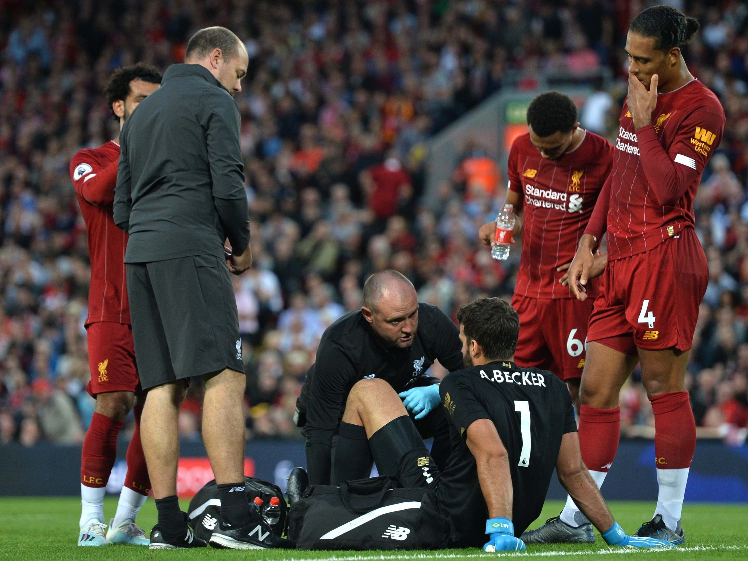 Alisson is treated for injury during the match against Norwich