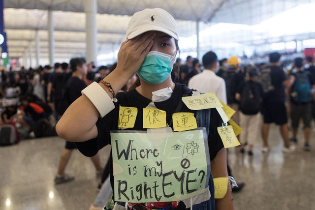 A protester hides her right eye during an occupation of Hong Kong's Chek Lap Kok International Airport in August, 2019
