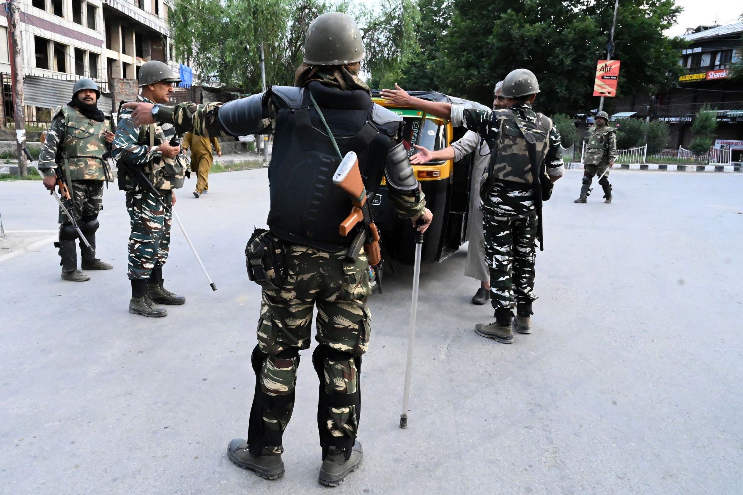 Security personnel stop an auto-rickshaw for questioning at a roadblock during the lockdown in Srinagar on Monday