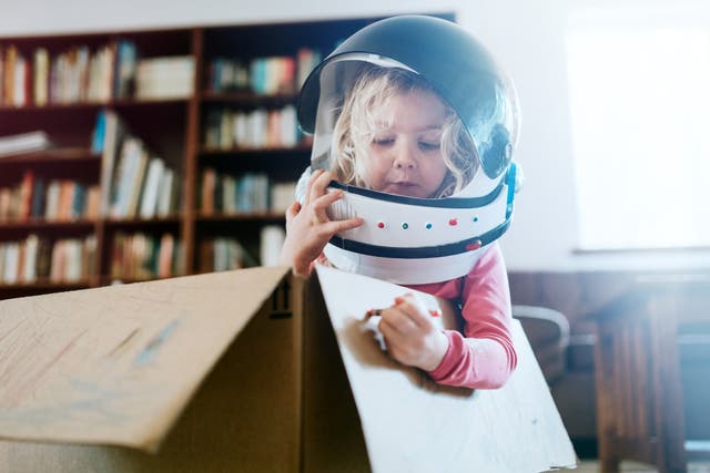 Child Imagines Space Adventure in Cardboard Box