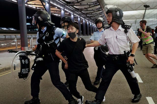 Policemen arrest a protester during a clash at the Airport in Hong Kong.