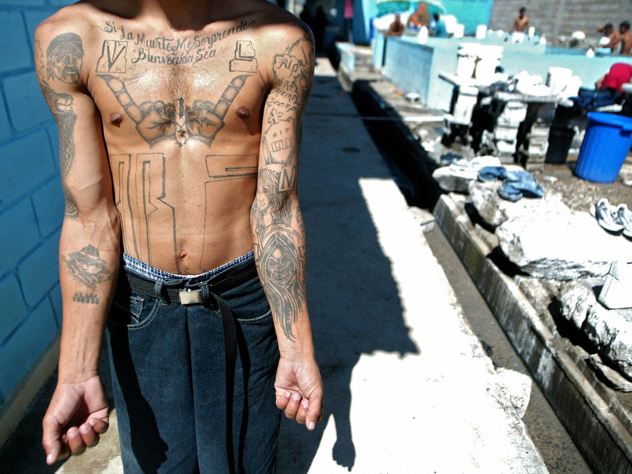 An unidentified member of MS-13 shows off his tattoos in the unit where he is imprisoned in Tamara, Honduras