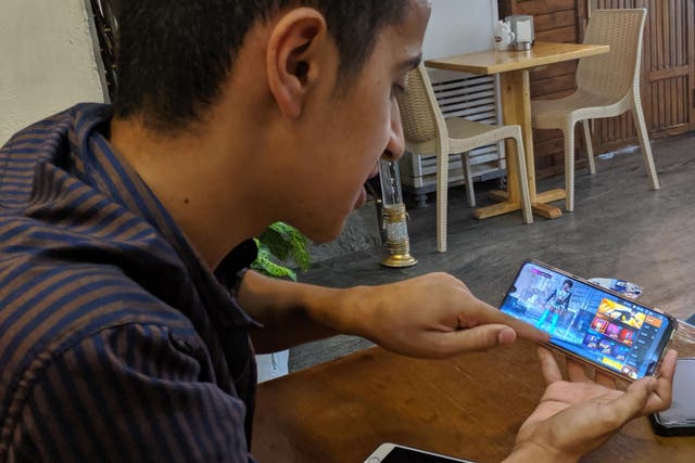 Mustafa Majid, 18, plays PUBG on his phone at a coffee shop in the Iraqi capital