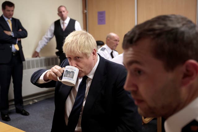 Boris Johnson takes a drink from a prison mug