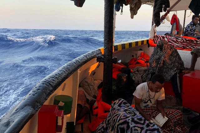 A migrant reads verses of the Quran aboard the Open Arms Spanish humanitarian boat as it arrives near the Lampedusa coast in the Mediterranean Sea