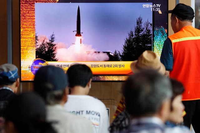 South Korean people watch a breaking news broadcast about North Korea's missile launch in Seoul