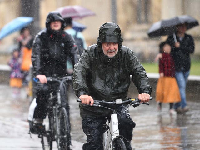 Cyclists battle through heavy rain in Cambridge on Wednesday as the UK is hit by wet weather