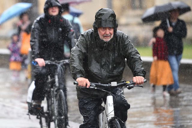 Cyclists battle through heavy rain in Cambridge on Wednesday as the UK is hit by wet weather