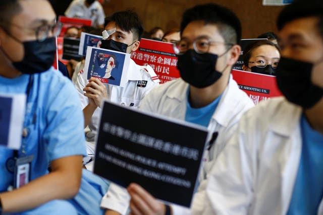 Medical staff denounce police brutality during anti-government protests at Queen Elizabeth Hospital in Hong Kong