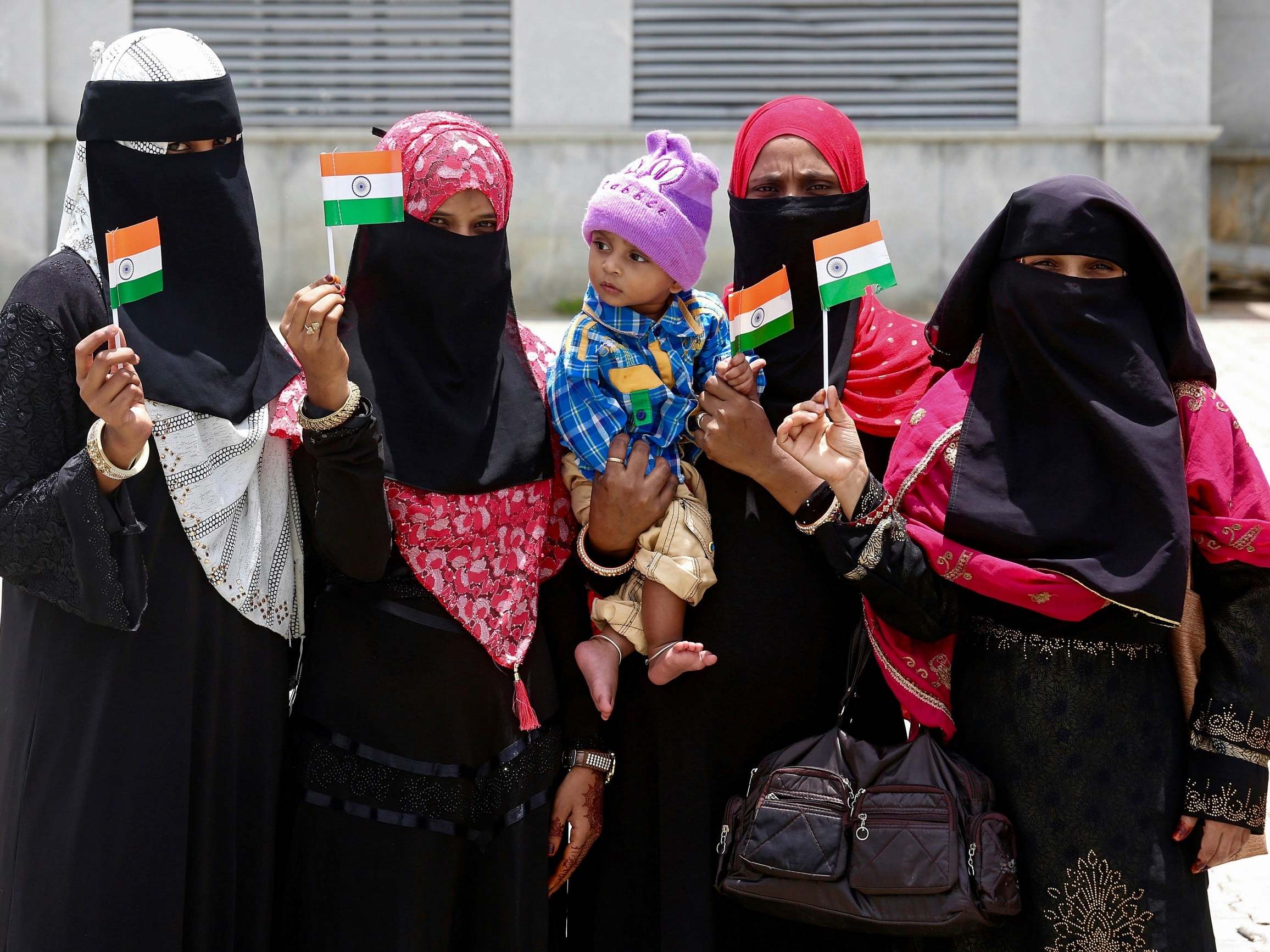 Indian Muslim women pose with Indian flags on the anniversary of independence from British rule in Bangalore, India