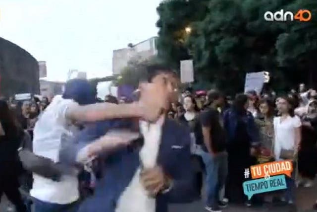 Still image of a journalist being punched in the face live on air while reporting on feminist protests in Mexico City.