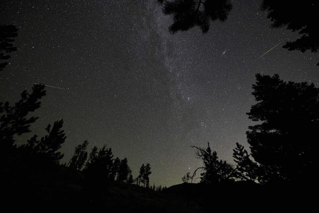 Two Perseid meteors (L&amp;R) are seen near the Andromeda Galaxy (2nd-R) and the Milky Way (C) over Rocky Mountain National Park in Colorado in the early morning hours of August 12, 2018