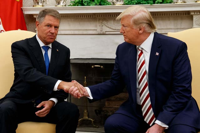 President Donald Trump and Romanian President Klaus Iohannis shake hands during a meeting in the Oval Office