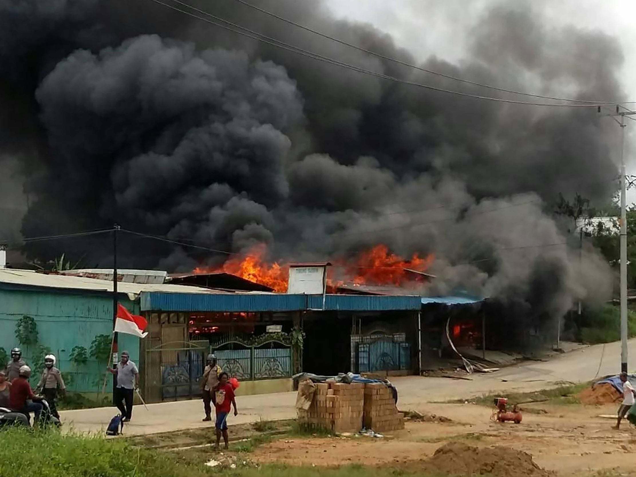 Rioting demonstrators set fire to a building in Sorong, Indonesia