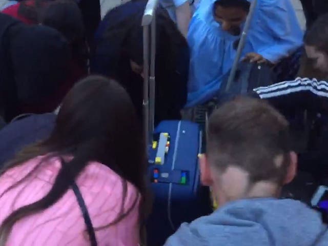Still image taken from video of strangers helping woman pick up 3,200-piece Lego set after she dropped it at London Euston station, 21 August 2019.