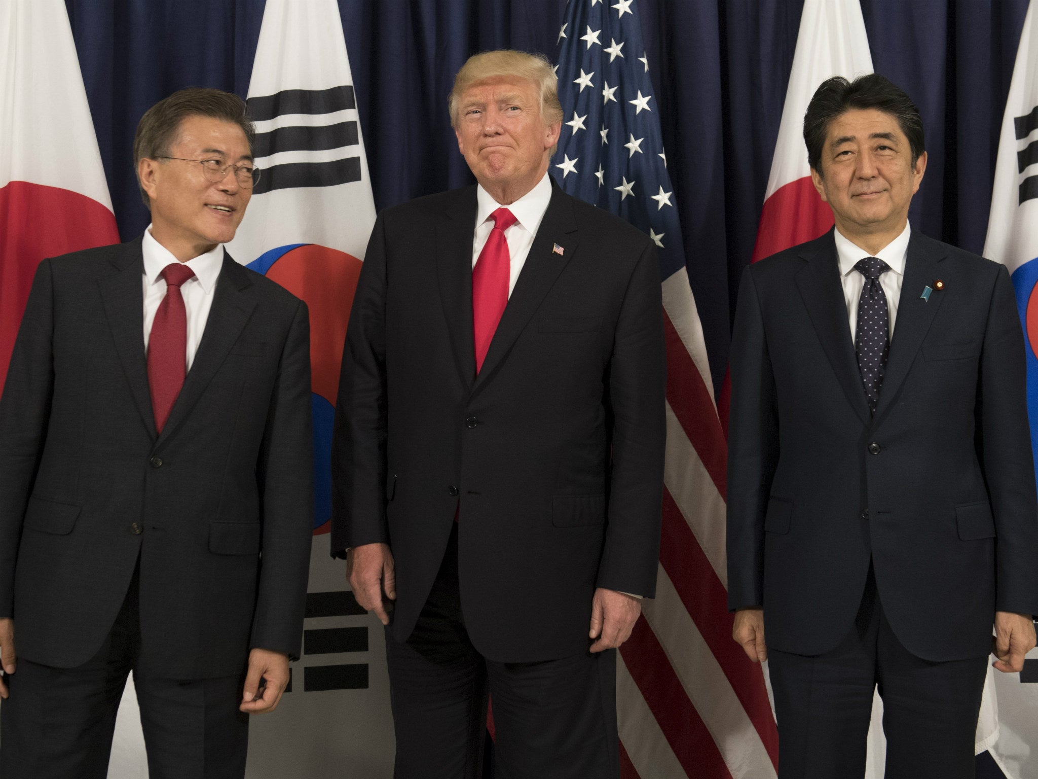 South Korea’s Moon Jae-in (left) and Japan’s Shinzo Abe will likely look to Trump to solve the escalating diplomatic spat between the two nations