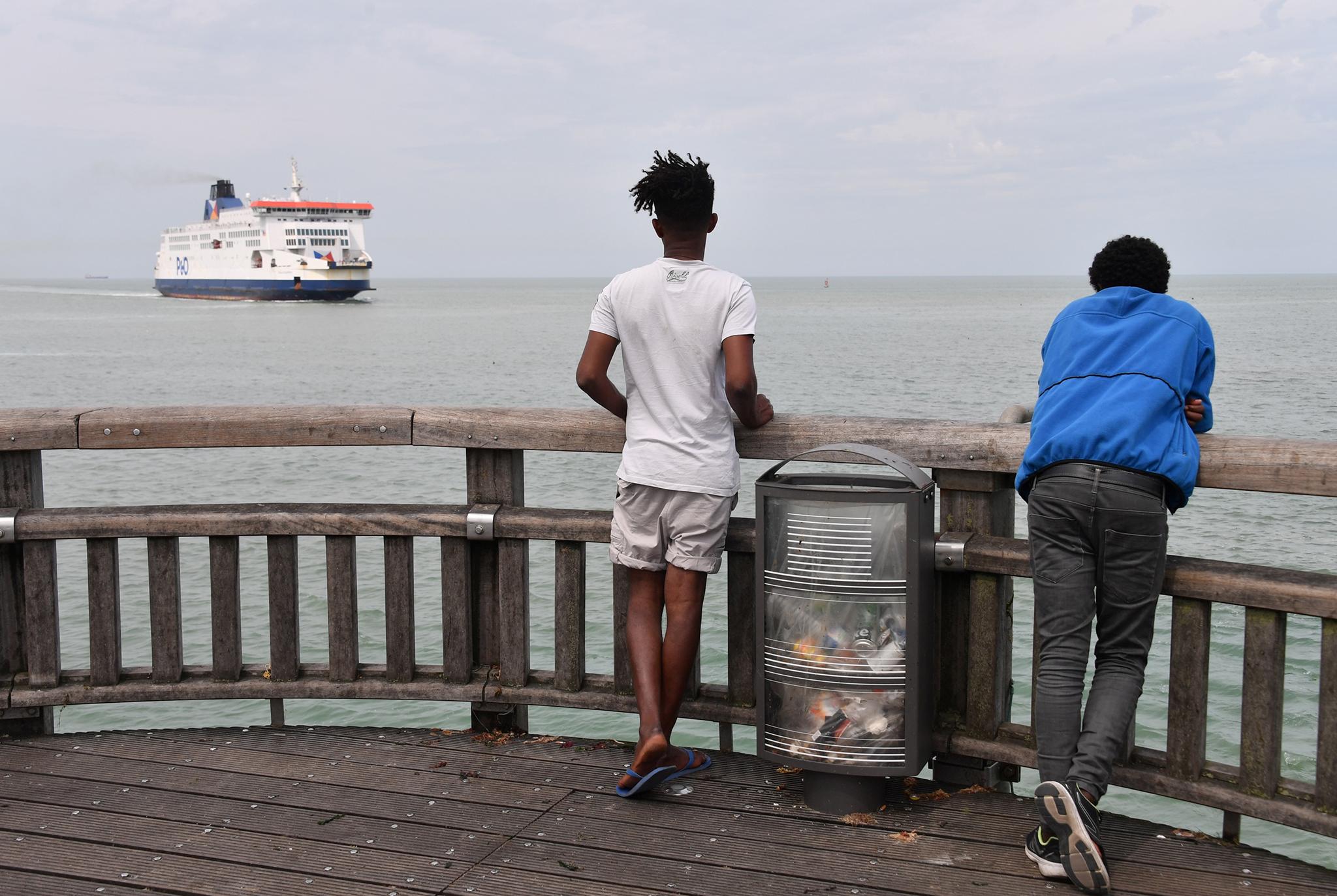 Eritrean migrants observe a ferry arriving in the French port from the UK this month