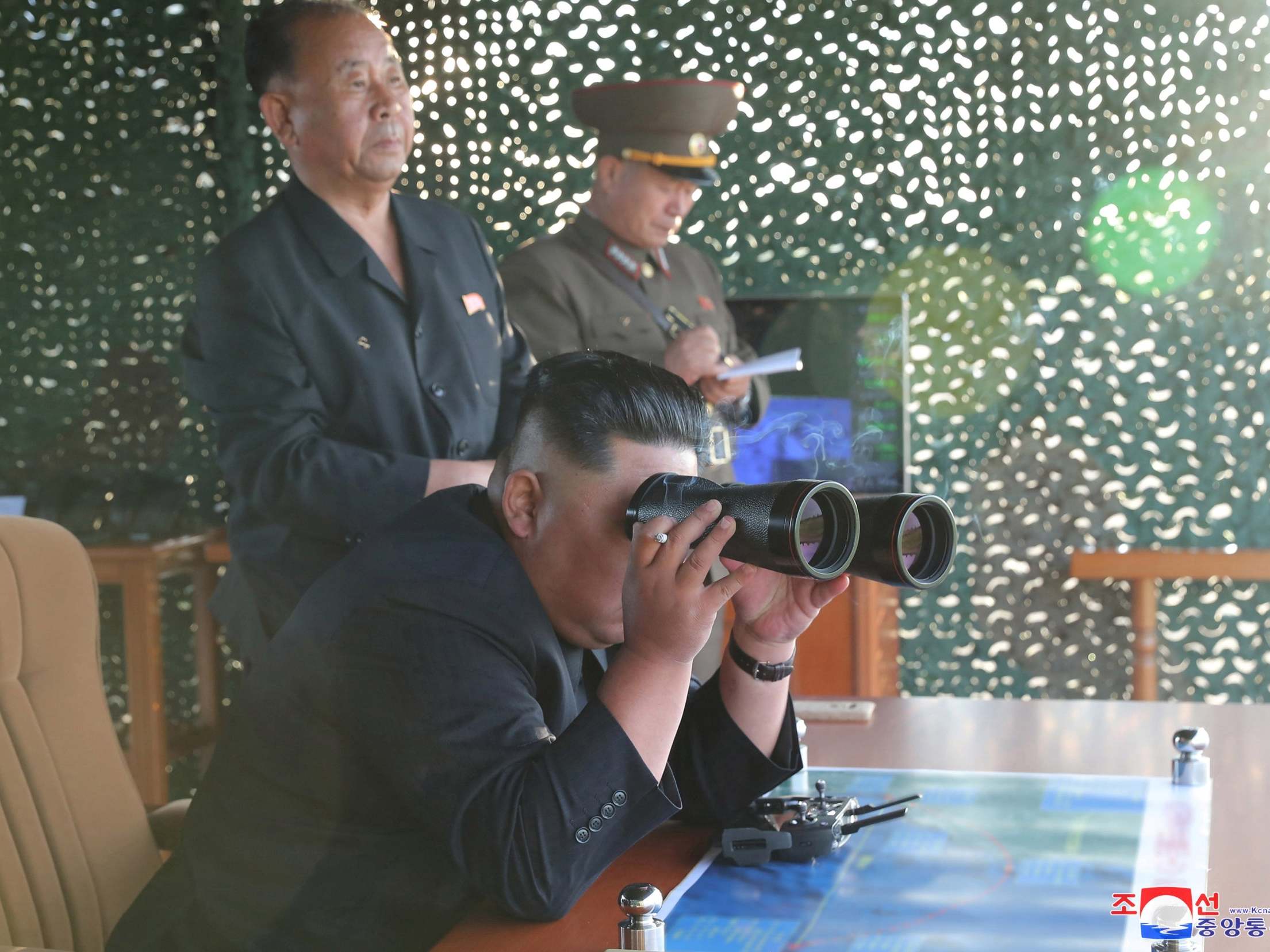 Kim Jong Un pictured watching the test of a multiple rocket launcher, according to state media