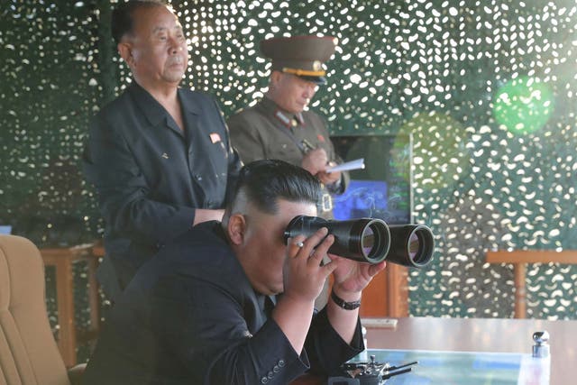 Kim Jong Un pictured watching the test of a multiple rocket launcher, according to state media