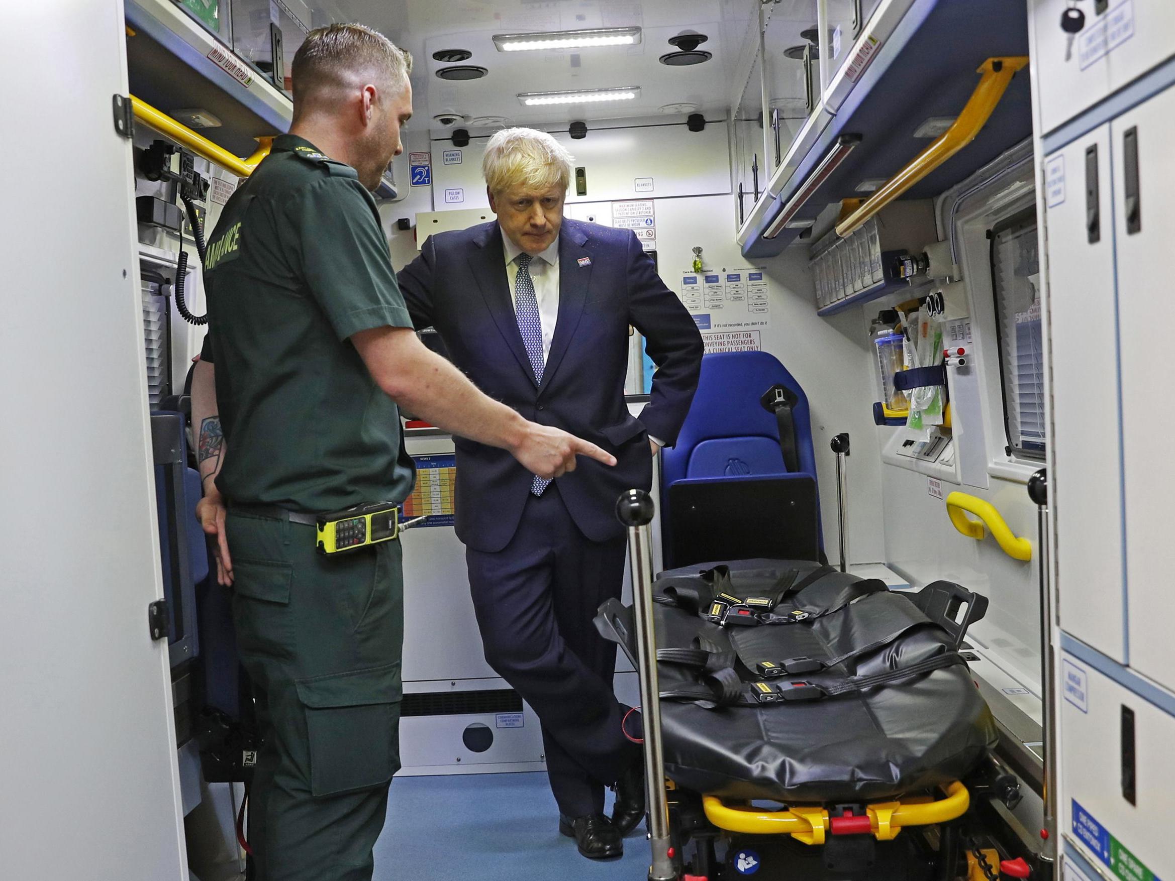 File: Boris Johnson is shown around an ambulance. Cancer Research UK says 'government inaction on staff shortages is crippling the NHS'