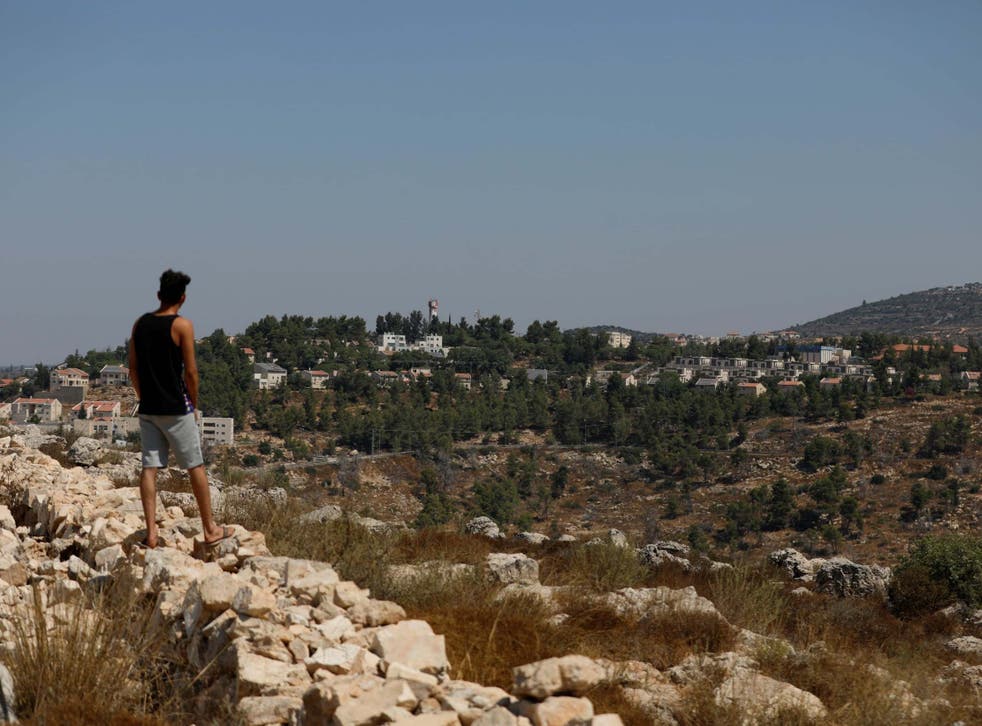 A man stands near the scene of an explosion near the Jewish settlement of Dolev in the Israeli-occupied West Bank, 23 August