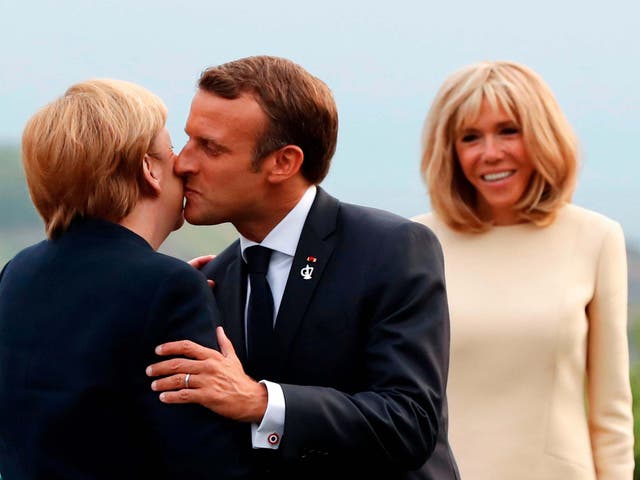 Brigitte Macron looks on as her husband greets German chancellor Angela Merkel at the G7 summit