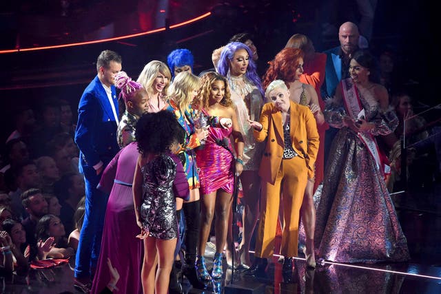 Taylor Swift accepts the award for best video at the VMAs with the cast of 'You Need to Calm Down'
