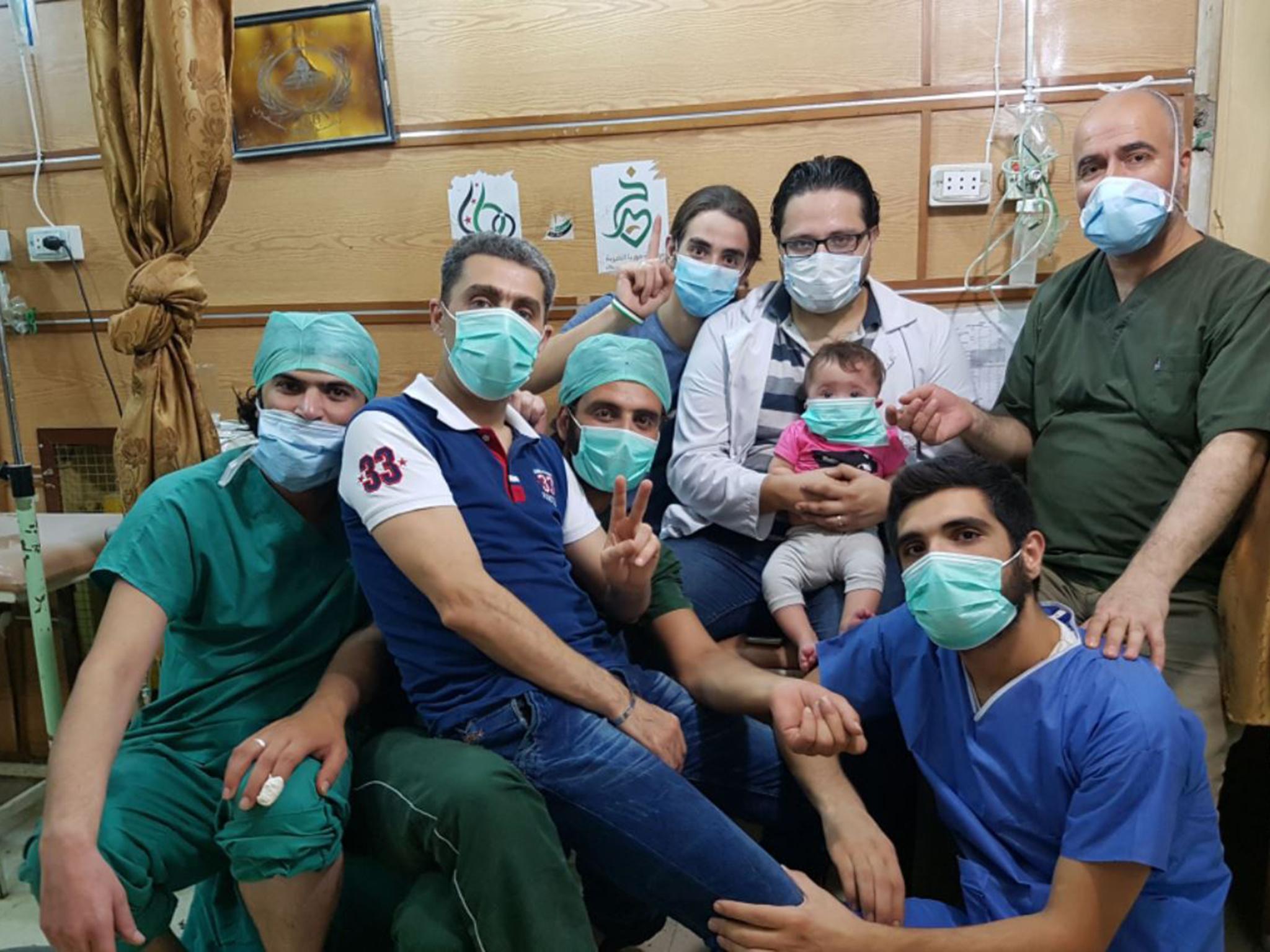 Hamza, holding Sama, and the staff of al-Quds hospital