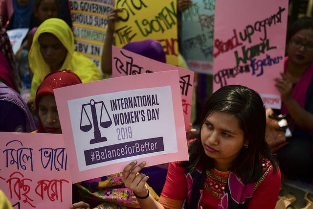 File: Bangladeshi women hold placards as they take part in a rally to mark International Women's Day in Dhaka