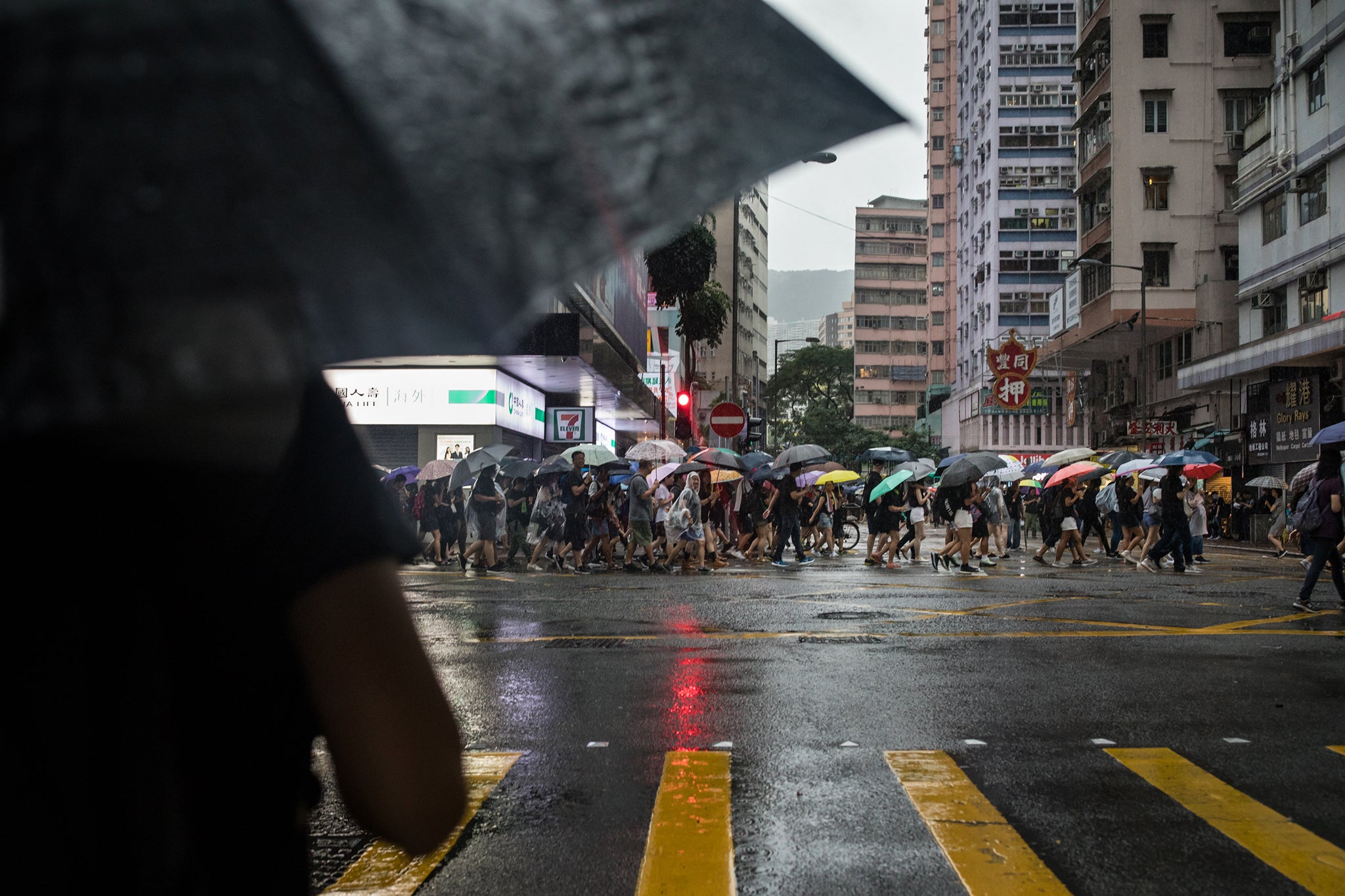 Under heavy rain, Gigi walks to join other protesters in their march through Wan Chai