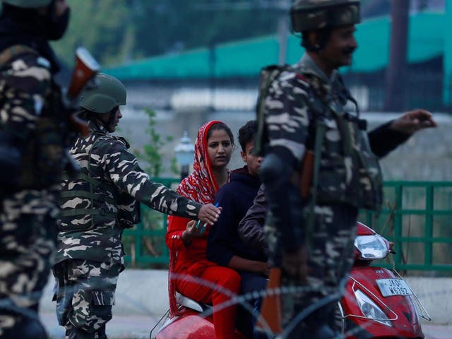 Indian security personnel stop Kashmiri residents on 23 August