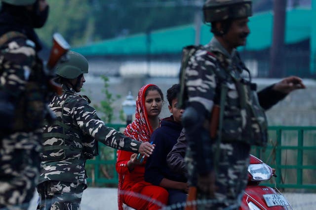 Indian security personnel stop Kashmiri residents on 23 August